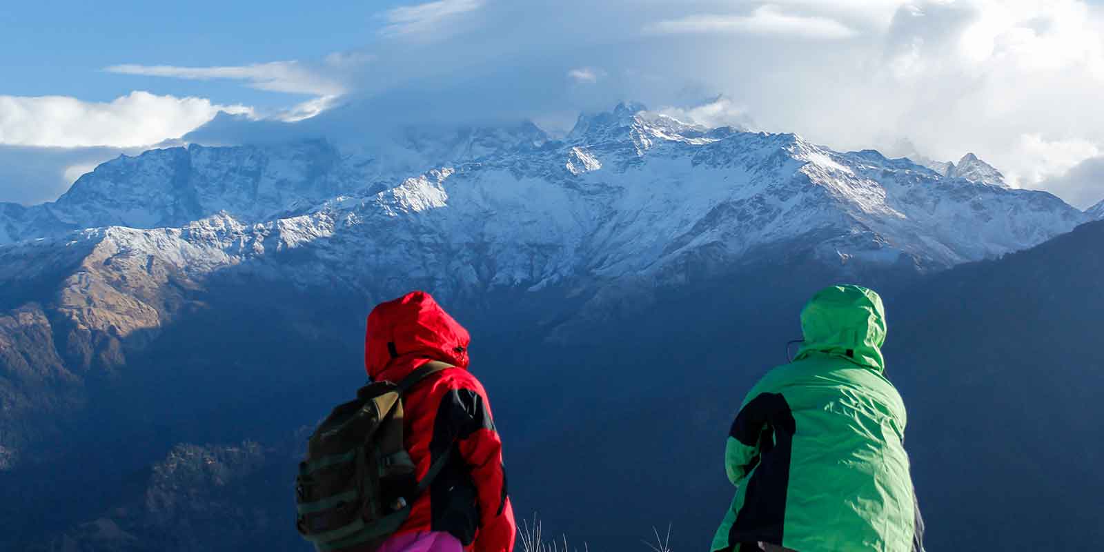 Two trekkers on summit of Poon Hill looking out to Annapurna range