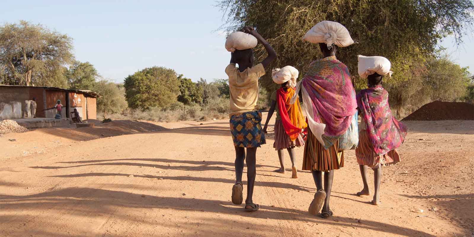 African women carrying supplies to their village community
