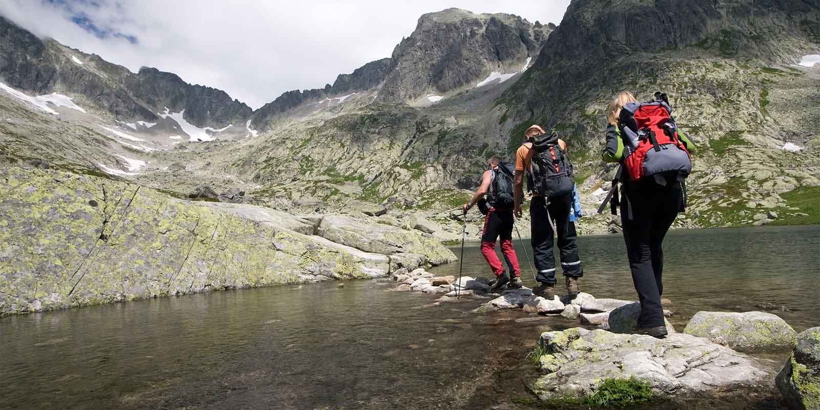 Trekkers crossing water on a mountain expedition
