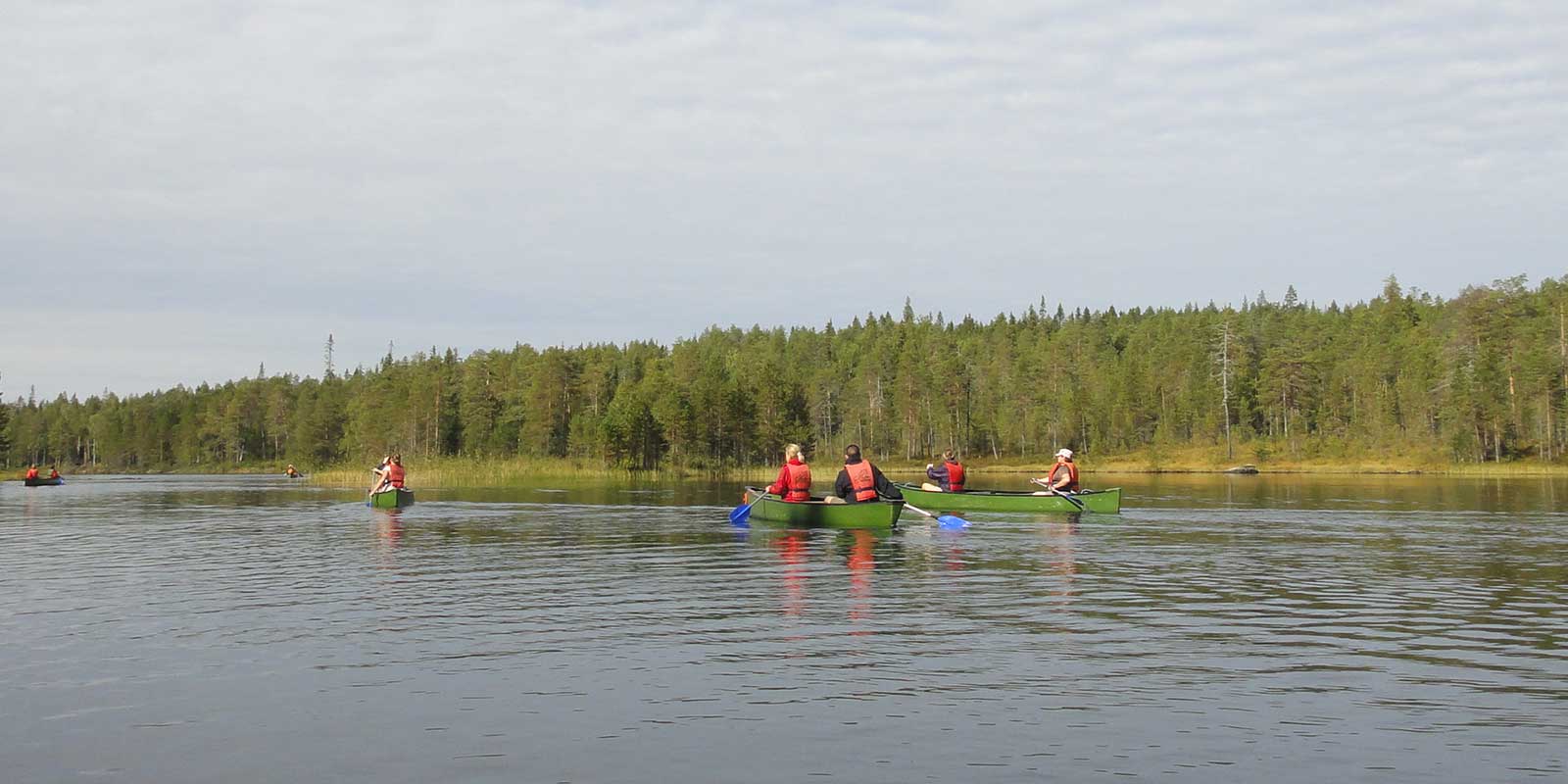 Group canoeing on river in Finland 