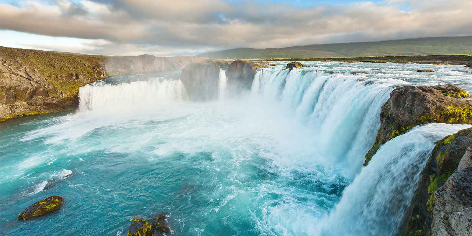 Godafoss waterfall cascading into blue lagoon