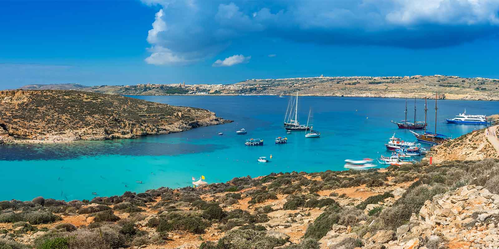 Panorama of turquoise Blue Lagoon and boats on Comino Island, Malta