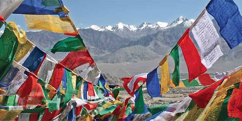 Prayer flags flying against a backdrop of the snow-capped Himalayas