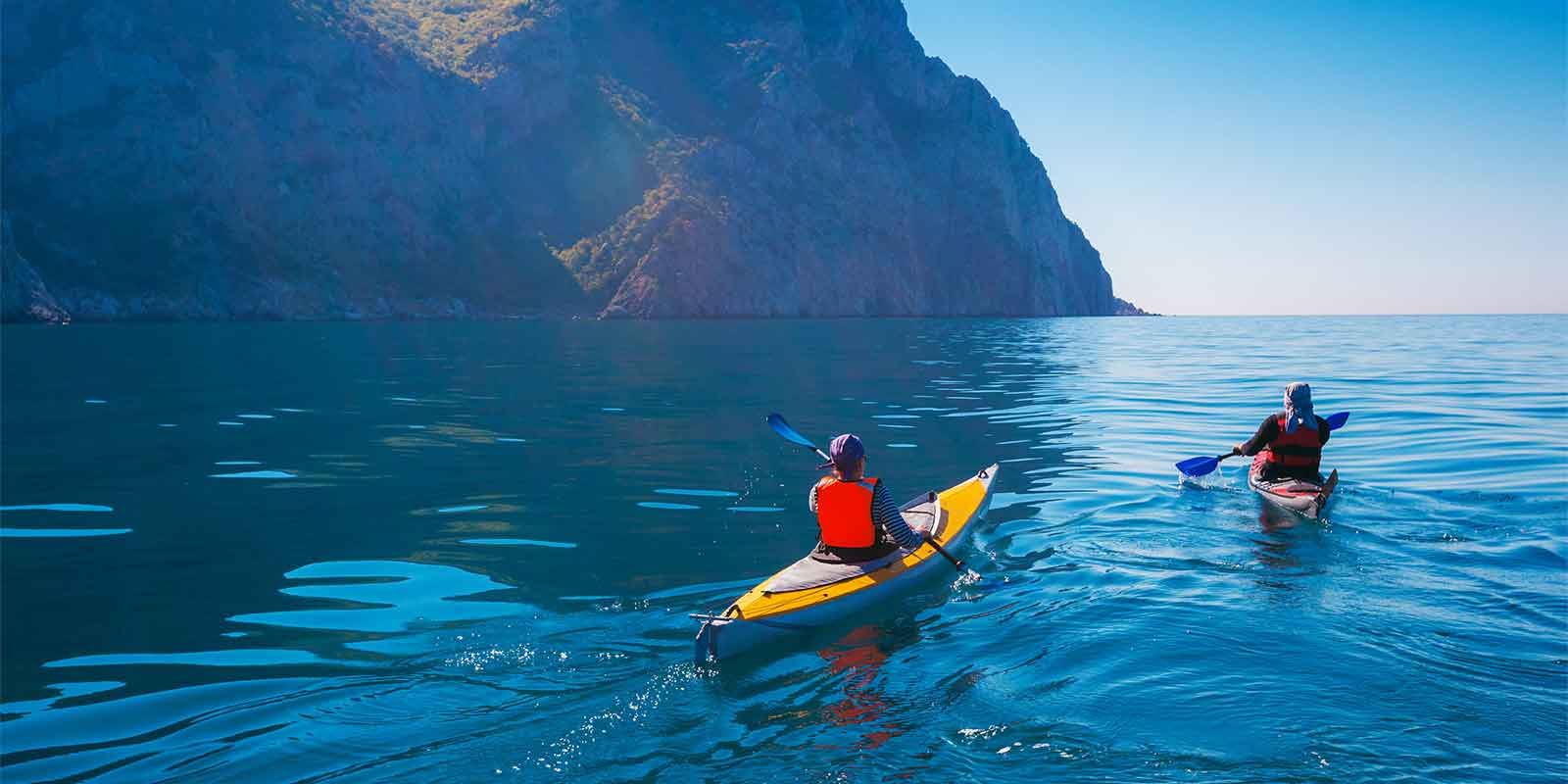 Pair of kayakers paddling around the coast