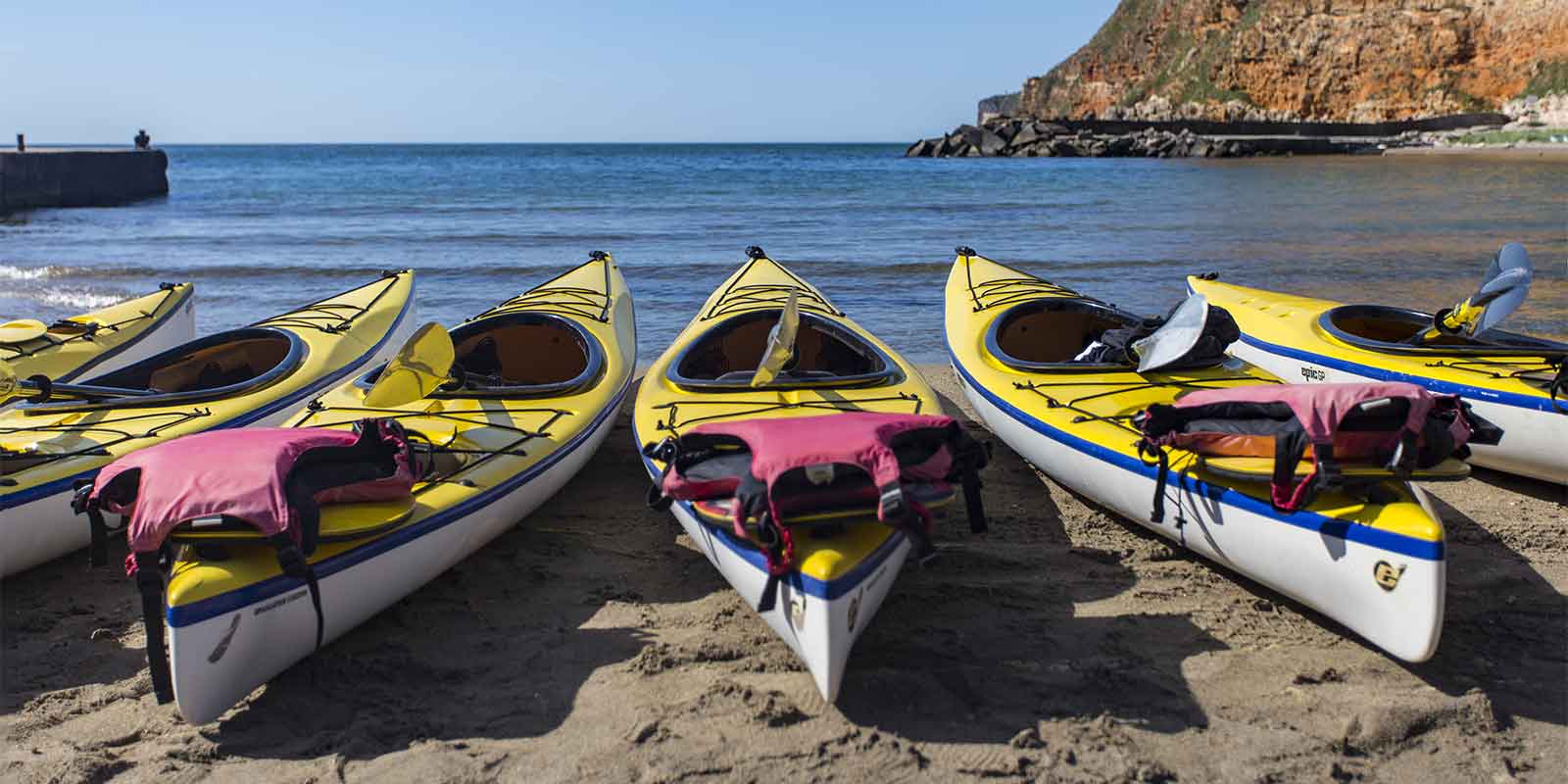 Kayaks and lifejackets waiting on the beach