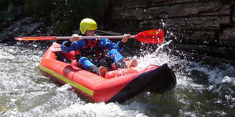 Student traversing white-water in a kayak. 