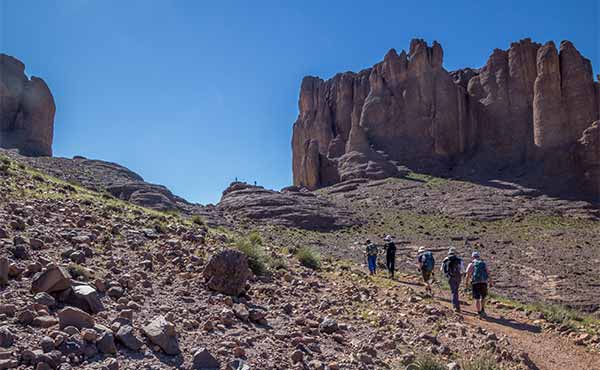 Group trekking in Jebel Sahro mountain range surrounded by rocky peaks