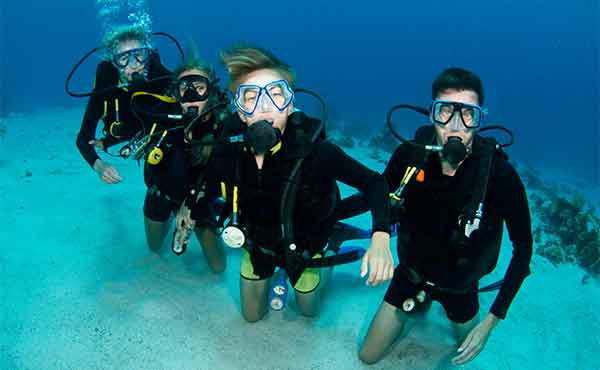 Group of young people learning to dive in the sea