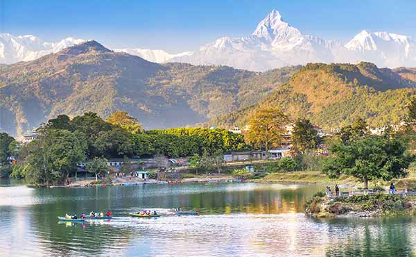 Boats on Phewa Lake with snow-capped Himalayas in the background