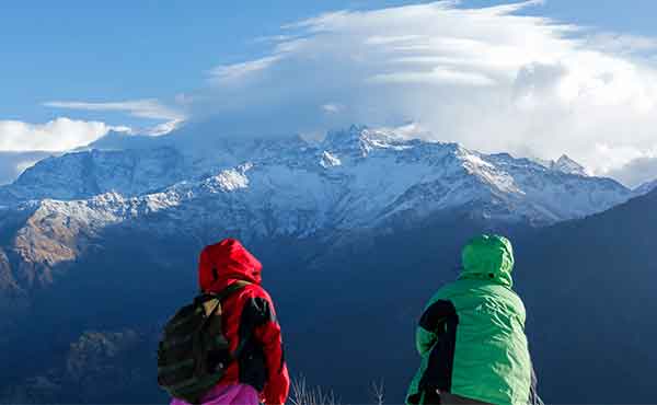 Two trekkers on summit of Poon Hill looking out to Annapurna range