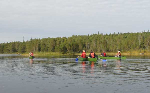 Group canoeing on river in Finland 