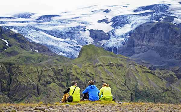 Three hikers sitting overlooking a valley in Thorsmork, Iceland