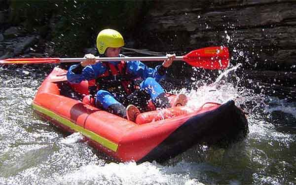 Student traversing white-water in an inflatable kayak